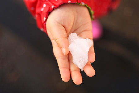 The hands of children with snow