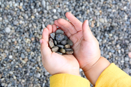 The hand of a child with a stoneの写真素材