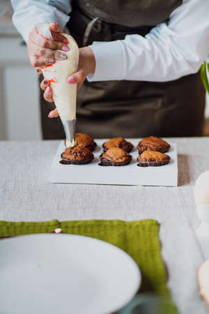 Chocolate muffins in the hands of a female pastry chef.
