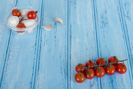 Fresh assorted vegetables and fruits, surrounding an empty blue cutting surfaceの写真素材