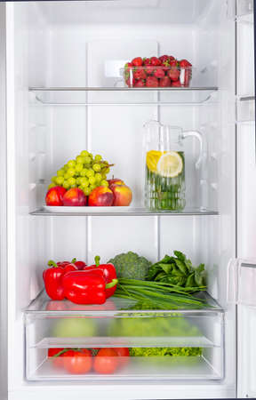 Open fridge full of fresh fruits and vegetables, healthy food background, organic nutrition, health care, dieting conceptの写真素材