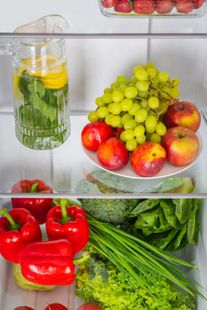Open fridge full of fresh fruits and vegetables, healthy food background, organic nutrition, health care, dieting conceptの写真素材