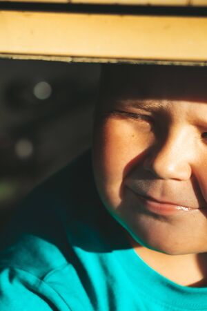 Vertical portrait of a pensive fat boy. Full sweaty boy with blond hair. The child is thinking about...