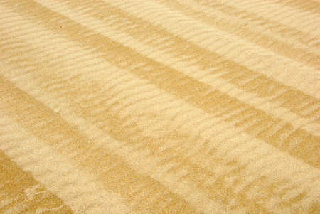 Waved beach sand background with old weathered vehicle tracks. Diagonal orientationの写真素材