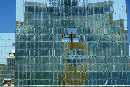 Heliostatâ plain mirror, which turns with the Sun and reflects sunlight toward one target â solar furnace (seen in reflection). Abstract science background. の写真素材