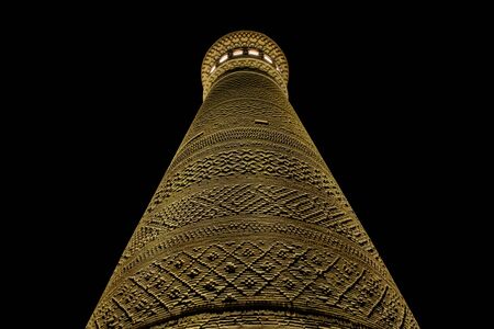 Kalyan minaret in Bukhara. Old ancient minaret in electric lights. Night view.の写真素材