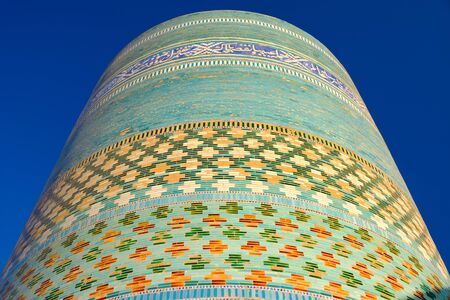 Kalta Minor minaret in Khiva, Uzbekistan. Multi-colored tiled huge ancient minaret in old townの写真素材