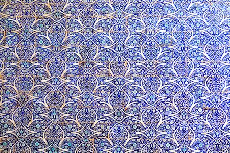 Maiolica style tin-glazed pottery tiled wall in ancient Khiva mosque in Uzbekistan. Abstract art background.の写真素材