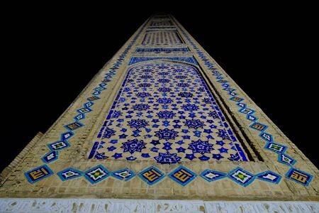 Old ancient minaret with blue glaze tile at night, Uzbekistan. Central Asia travel viewの写真素材