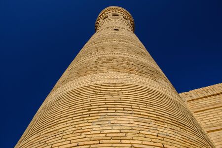 Old ancient minaret on the sky background. Central Asia travel view.の写真素材