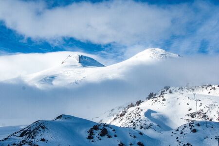 Mount Elbrus in sunlight above clouds. Caucasus mountains winter viewの写真素材