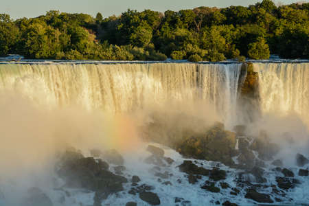 Niagara Falls during sunrise. beautiful multicolored rainbow on the background of a waterfallの写真素材
