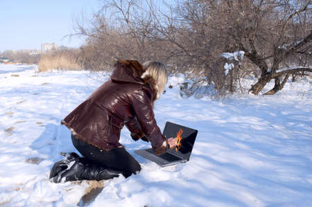 The girl heats hands about fire on the notebook monitorの写真素材