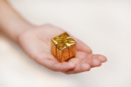 small yellow gift on the woman's handの写真素材