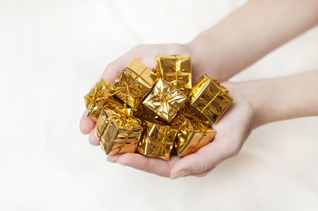 heap of yellow gifts in the handsの写真素材