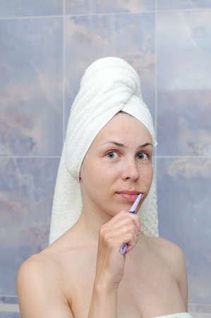 young woman cleaning the teeth with a brushの写真素材