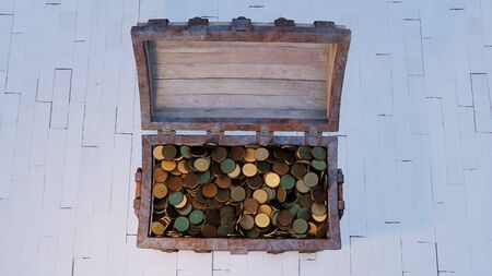 Top view of an old wood with rusty metal Chest totally Opened and full of Gold Coins put on a white wood floorの写真素材