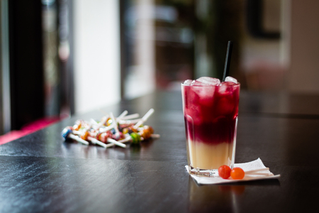 Cherry banana juice fruit cocktail on wooden table decorated with lollipopsの写真素材