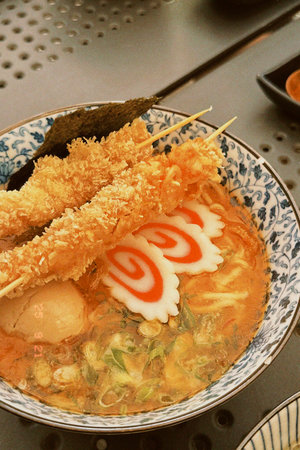 Bowl of ramen filled with noodles, garnished with fresh green onions, highlighting the rich textures and flavors of Japanese cuisineの写真素材