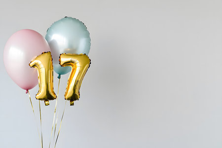 Pastel colors, the letter 17 from a gold foil balloon on a white minimalist background with space for text.の素材