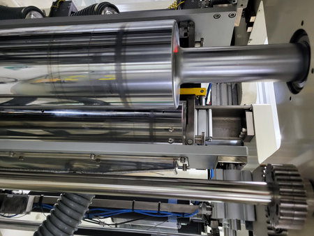 Close-up view of industrial machinery with metallic rollers and components, highlighting advanced...