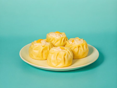 Steamed dumplings on a plate on a turquoise background