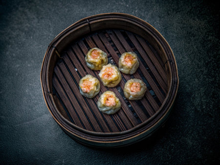Shrimp dumplings in bamboo basket on black stone background.の写真素材