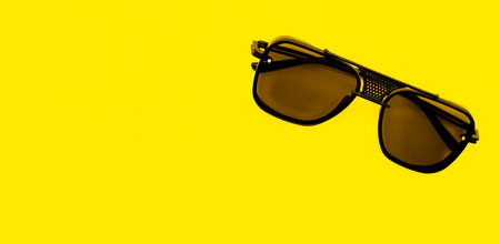 stylish sunglasses isolated on a yellow background with a blank space for your textの写真素材
