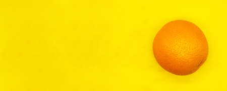 juicy ripe orange isolated on a yellow background close up with a blank space for your textの写真素材