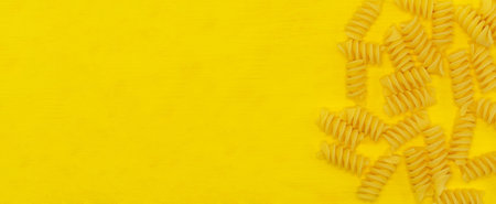 pasta isolated on a yellow background close up with a blank space for your textの写真素材
