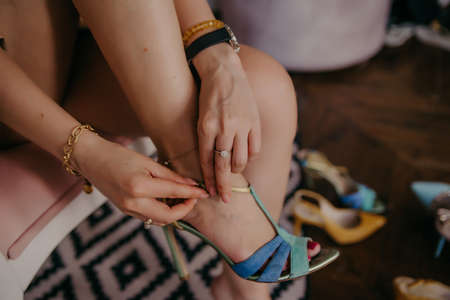 Young woman trying on different shoes at homeの写真素材