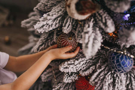 girl holding a christmas ball on the treeの写真素材