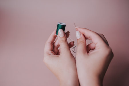 green thread and needle in handの写真素材