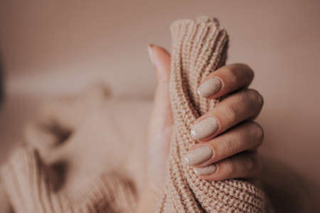 female hand on beige background. manicureの写真素材