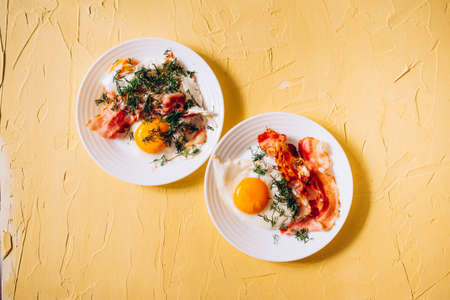 scrambled eggs with bacon and herbs for breakfast on the backgroundの写真素材