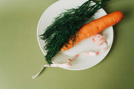 proper nutrition. dill, carrots and centimeter on a green backgroundの写真素材