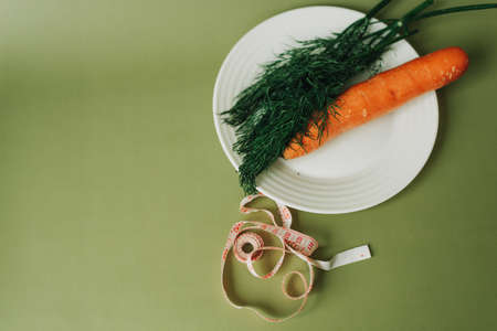 proper nutrition. dill, carrots and centimeter on a green backgroundの写真素材