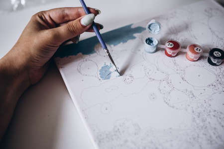 Drawing a picture by numbers with paints. Coloringの写真素材