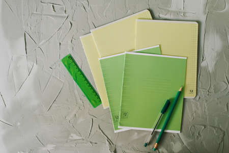 school notebook and pencil with pen and ruler on table on gray backgroundの写真素材