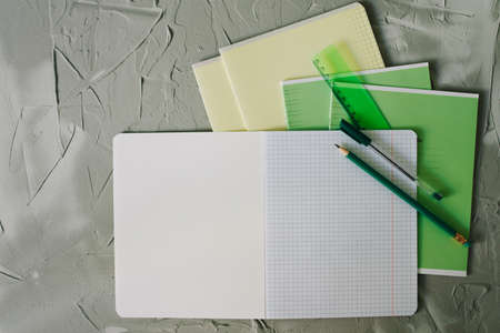 school notebook and pencil with pen and ruler on table on gray backgroundの写真素材