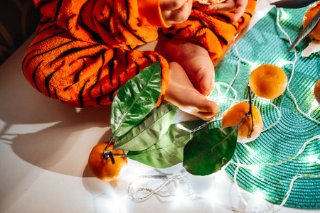 child in tiger costume eating tangerinesの写真素材