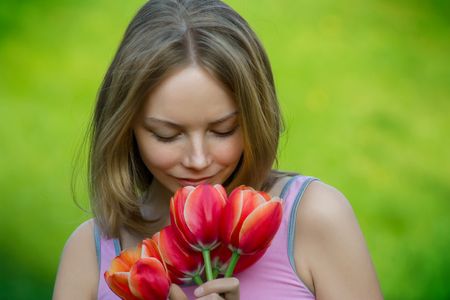 beautiful young lady with flowers outdoor smilingの写真素材
