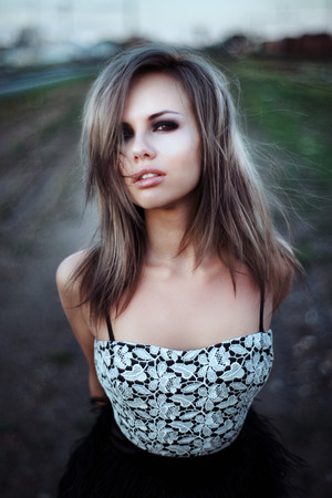 Beautiful young woman close-up,  against green of summer park.の写真素材