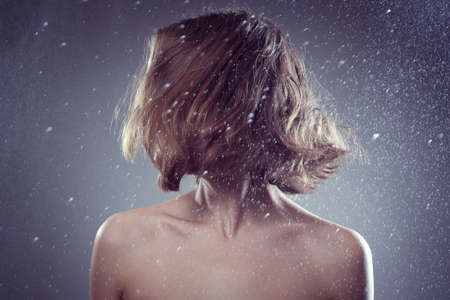 Photo of smiling beautiful woman with magnificent hair  in rain and catches dropsの写真素材