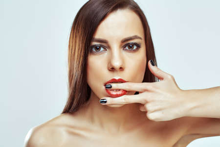 portrait of cute beautiful young girl with finger in her mouthの写真素材