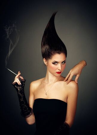 Helloween. Mysterious woman in dark hood with cigaretteの写真素材