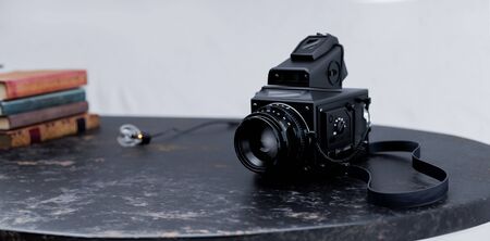 Retro photo camera on table. Creative 3D concept. Vintage style background.の写真素材