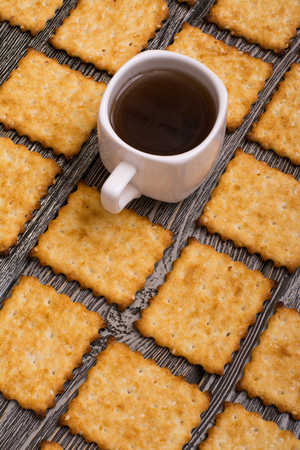 small cup of coffee and cookies on wooden background