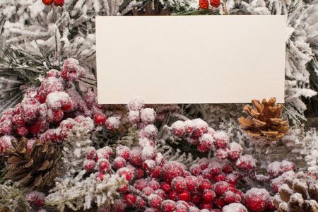 Fir branch and berries in snow, cone on wooden background. Christmas theme. Templateの写真素材