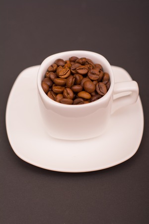 Coffee beans in a white cup on a dark backgroundの写真素材